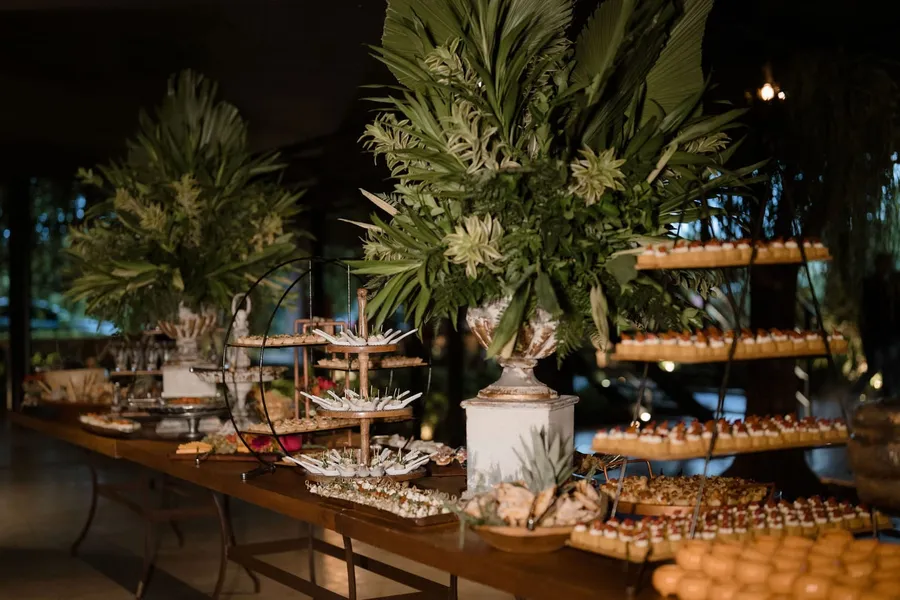 Arranjo floral sobre mesa de casamento montada pelo Buffet Bom Gosto