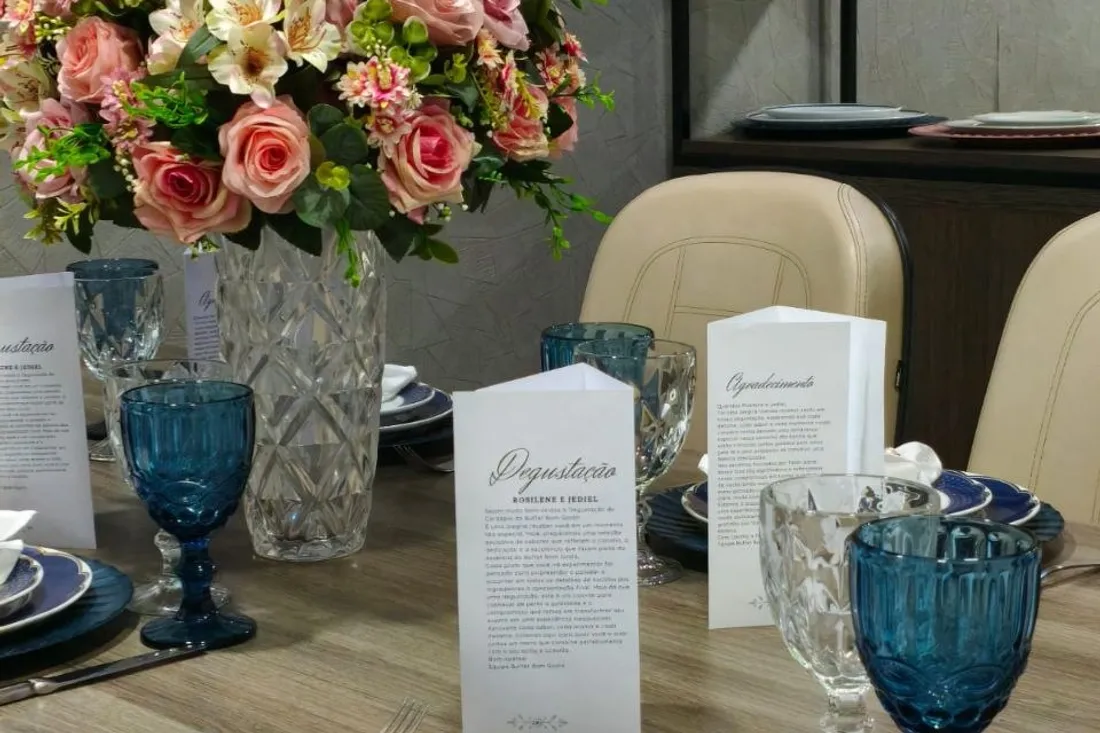 Mesa de gala posta com rosas, taças de cristal e sousplat dourado