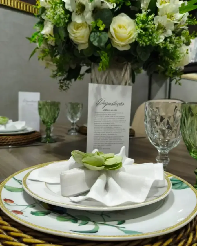 Mesa de degustação do Buffet Bom Gosto com arranjo de flores e menu impresso
