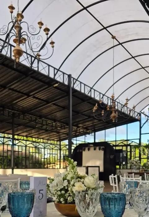 Salão montado para um grande casamento, com mesas postas e estrutura completa