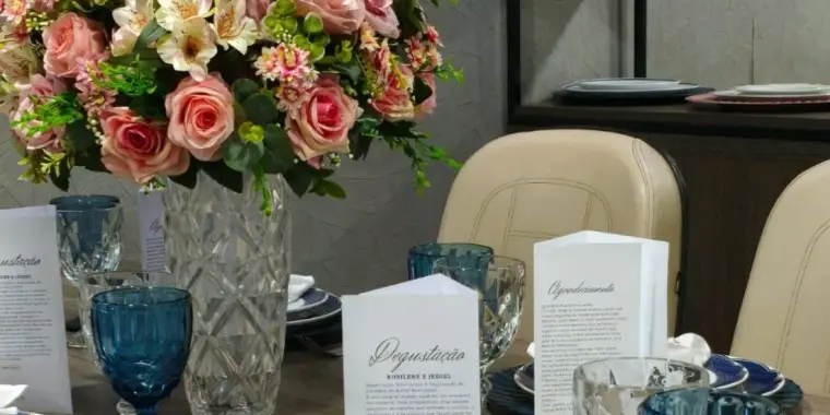 Mesa de gala com rosas, taças de cristal lapidado e menu impresso