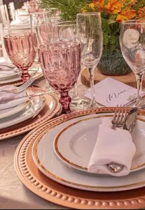 Lugar posto com sousplat rosé, louça e taça de cristal